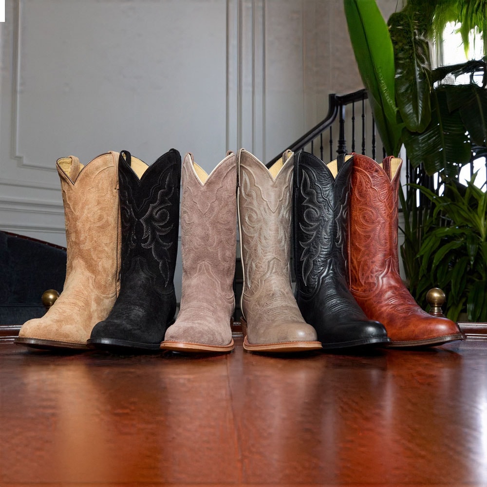 A lineup of the Marco and Plano 12” Western boots in various colors on a coffee table.